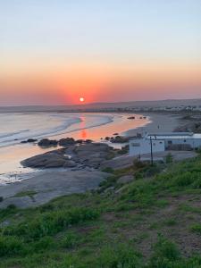 a sunset over a beach with the sun setting at The Oystercatchers Haven at Paternoster in Paternoster