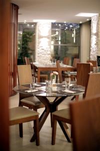 une salle à manger avec une table, des chaises et des verres dans l'établissement Lijam Hotel, à Amman