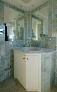 a bathroom with a sink and a mirror at Hotel Villa Gemella in Baja Sardinia