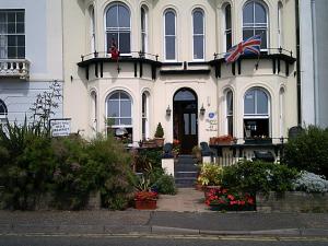 a white house with an american flag in front of it at Regency House in Walton-on-the-Naze