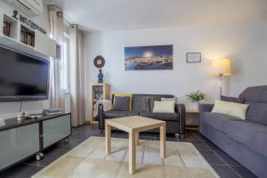 a living room with a couch and a tv at Bairro Alegre, Casa do Porto in Porto