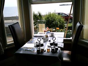 a table in a restaurant with a view of the ocean at Regency House in Walton-on-the-Naze