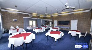 a dining room with red and white tables and chairs at Edenhope Motor Inn in Edenhope