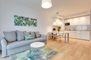 a living room and kitchen with a couch and a table at Wave Apartments - Nadmorze in Gdańsk