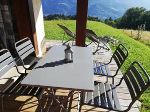 コンブルーにあるRez de chaussée très calme vue Mont-Blancの白いテーブルと椅子が備わるデッキから眺めの良い客室です。