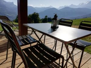 Rez de chaussée très calme vue Mont-Blanc في كومبلو: طاولة وكراسي على سطح مطل على الجبال