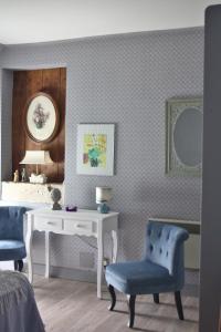 1 Schlafzimmer mit einem Schreibtisch und 2 blauen Stühlen in der Unterkunft petite maison berrichonne in Chârost