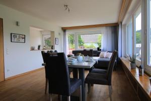 a dining room and living room with a table and chairs at Wohnung Talblick in Schleiden