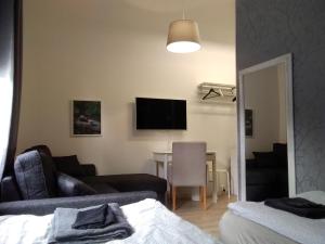 a living room with a couch and a tv on the wall at Wanhan Aseman Majatalo in Savonlinna