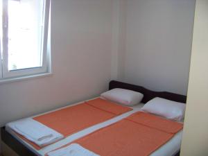 two beds in a small room with a window at Tedi & Kiki Apartment in Ohrid