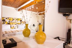 two yellow vases sitting on a table in a bedroom at Tsitsikhaya Lodge in Stormsrivier