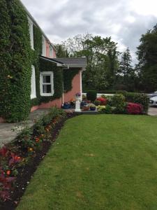 ein Haus mit einem grünen Garten mit Blumen in der Unterkunft Riverside apartment in Castlemaine