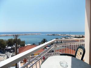 balcón con mesa y vistas al agua en Hotel Sgouridis, en Limenaria