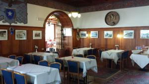 a dining room with tables and chairs and a clock on the wall at Hotel Savoia in Canazei