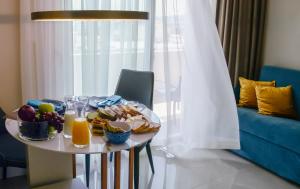 une table avec une assiette de nourriture et de jus d'orange dans l'établissement L - Suites, à Kavala