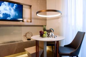 een kleine tafel in een keuken met een tv aan de muur bij L - Suites in Kavala