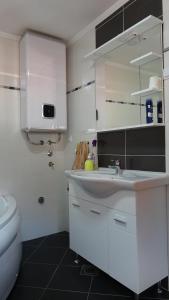 a white bathroom with a sink and a toilet at APARTMANI MIA VUKSANOVIC in Cetinje +38 photos