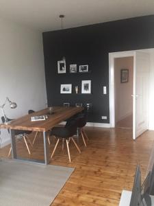 a dining room with a wooden table and black walls at Luxe Apartment am Rhein in Worms