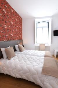 Un dormitorio con una gran cama blanca y una ventana en Glass Boutique - Rooms & Suites, en Marinha Grande