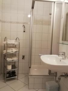 a white bathroom with a sink and a shower at Bernsteinfischer - Fewo mit 2 Balkone in Zempin