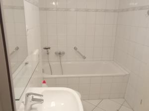 a bathroom with a tub and a sink and a toilet at Bernsteinfischer - Fewo mit 2 Balkone in Zempin
