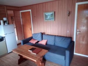 a living room with a blue couch and a table at Stenvåg Camping in Eidsdal