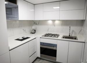 a white kitchen with a stove and a sink at Rawsheh 51 in Beirut
