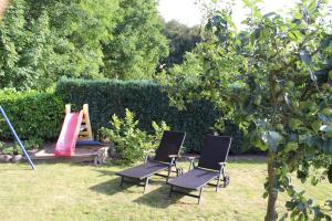 dos sillas sentadas en el césped en un jardín en Ferienwohnung Holzerland, en Patzig