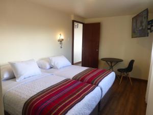 um quarto de hotel com uma cama e uma mesa em Casa Durand em Cusco