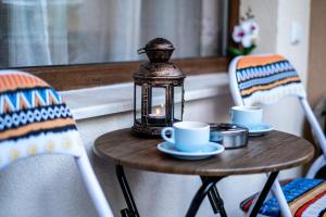 a table with two cups and a lantern on it at Alex apartment in Velingrad