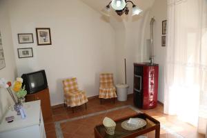 een woonkamer met een tv en een tafel en stoelen bij Casa Matteo Giovanni in Modica