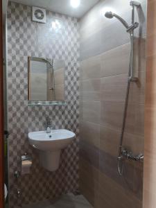 a bathroom with a sink and a shower with a mirror at стаи за гости Диневи in Kalofer