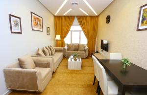 a living room with a couch and a table in it at Grand Dahlia Hotel Apartment - Sabah Al Salem in Kuwait