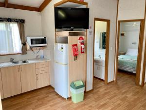 a small kitchen with a refrigerator and a sink at Tatura Cabin & Caravan Park in Tatura
