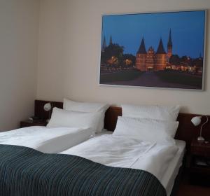 duas camas num quarto com uma fotografia na parede em Hotel Forsthaus St. Hubertus em Groß Grönau