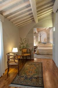 a bedroom with a bed and a table and a chair at Hotel Alla Corte degli Angeli in Lucca