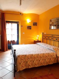 1 dormitorio con 1 cama en una habitación con paredes amarillas en B&B Locanda della Sesta Felicità, en Vaglio Serra