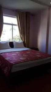 een slaapkamer met een groot bed en een raam bij Hai Duong Guesthouse in Hòa Bình