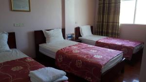 una camera d'albergo con due letti e una finestra di Hai Duong Guesthouse a Hòa Bình
