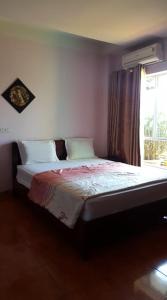 un letto in una stanza con finestra e gonna da letto tspectspectspectspectspects di Hai Duong Guesthouse a Hòa Bình