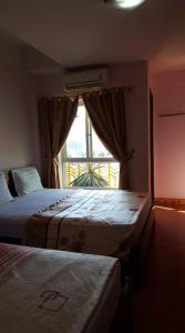 a hotel room with two beds and a window at Hai Duong Hotel in Hòa Bình