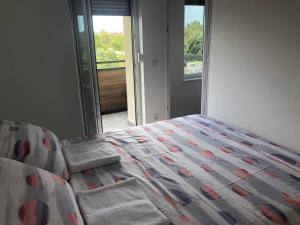 a bedroom with a bed with a comforter and a window at Portus in Zagreb