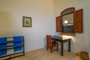 Zimmer mit einem Tisch, einem Fenster und einem Bett in der Unterkunft Villananda in Ambalangoda
