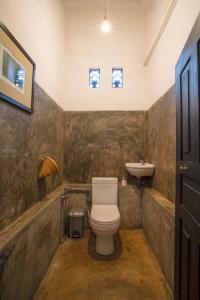 La salle de bains est pourvue de toilettes et d'un lavabo. dans l'établissement Villananda, à Ambalangoda