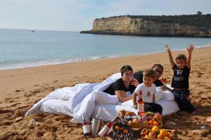 a family sitting on the beach with a tray of fruit at Casa Bela Moura, Boutique Hotel & Wine in Porches +94 photos