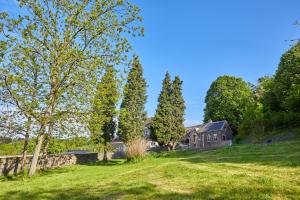 una casa en una colina con un campo verde y árboles en Gite des Coteaux en Lieja
