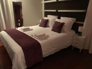- une chambre dotée d'un grand lit avec des draps et des oreillers blancs dans l'établissement Beau T4 Hyper Centre avec Parking, à Perpignan
