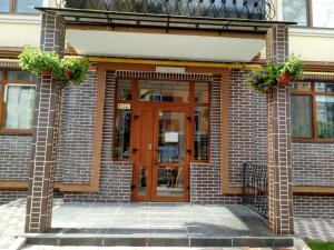 een bakstenen gebouw met een houten deur en bloemen bij Apartment Studio London 2 in Irpin'