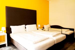 a bedroom with two beds with yellow walls at Ariston Appartment in Bolzano