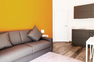 a living room with a couch and a yellow wall at Ariston Appartment in Bolzano